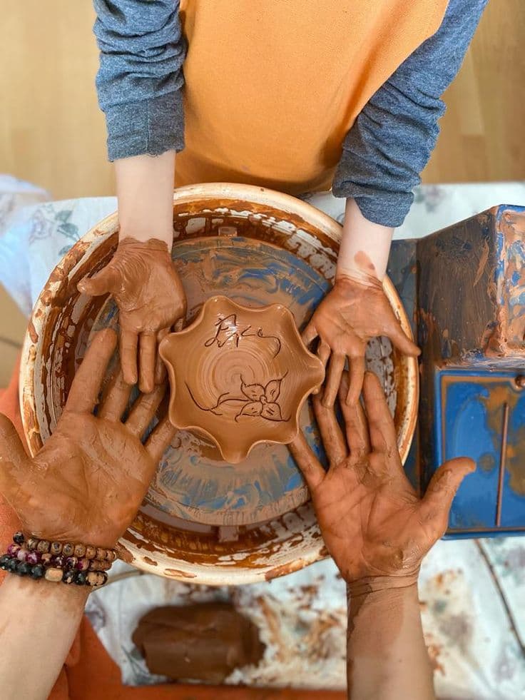 Adults working at the pottery wheel